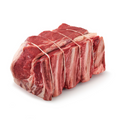 Raw rib roast tied with string on a white background