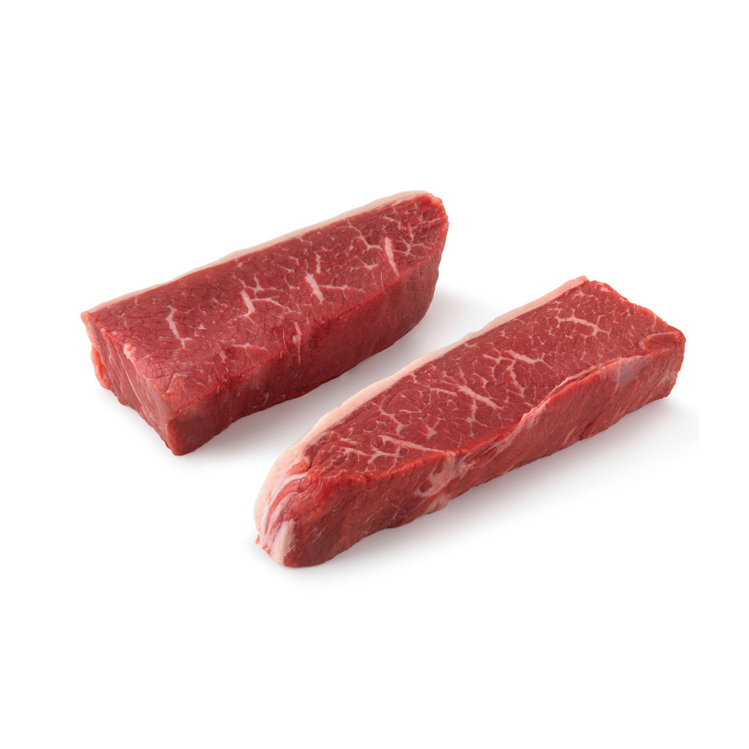 Two pieces of raw top sirloin steak on a white background