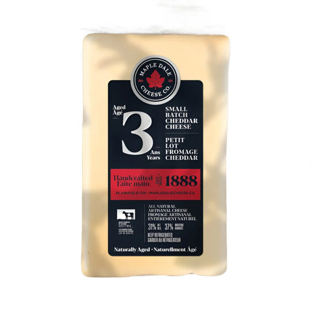 Block of cheddar cheese with a Maple Dale Cheese Co. label on a white background