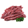 Raw beef slices with a sprig of parsley on a white background