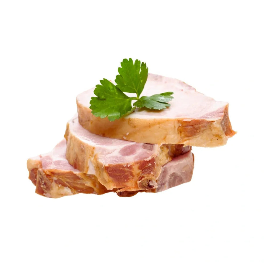 Stack of sliced cured meat with a sprig of parsley on a white background
