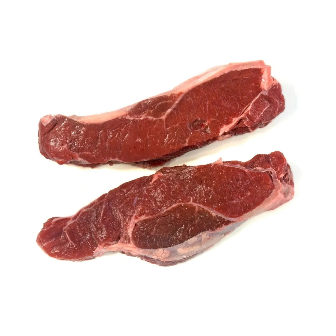 Two raw bison steaks on a white background