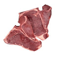 Raw bison t-bone steaks on a white background